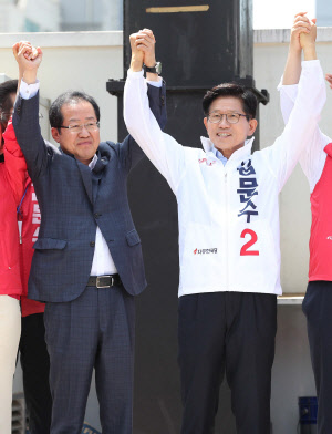 홍준표 자유한국당 대표가 지난달 31일 오전 서울역에서 열린 김문수 서울시장 후보 출정식에서 김문수 후보 등과 손을 맞잡고 시민들에게 지지를 호소하고 있다.  연합뉴스
